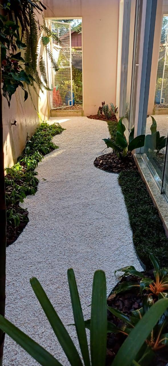 Jardim interno com pedrisco branco e forração verde
